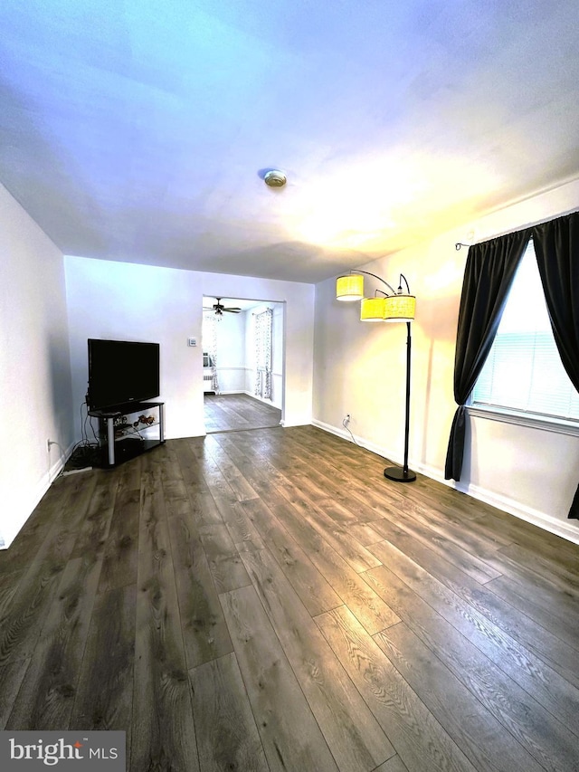 unfurnished living room with ceiling fan and dark hardwood / wood-style floors