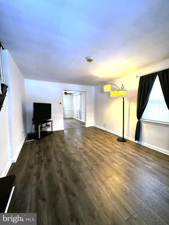 unfurnished living room with ceiling fan and dark hardwood / wood-style floors