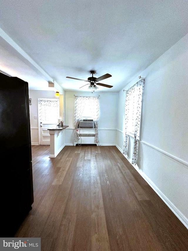 unfurnished living room with radiator, ceiling fan, dark hardwood / wood-style floors, cooling unit, and a textured ceiling