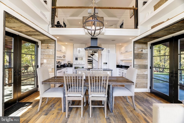 dining room with french doors, plenty of natural light, and hardwood / wood-style floors