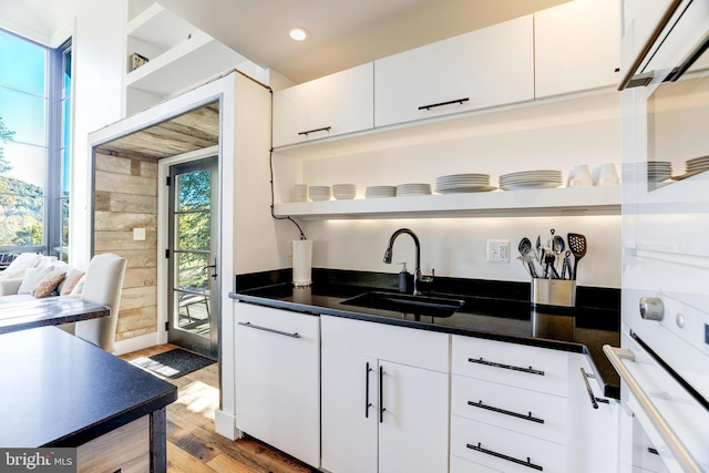 kitchen with open shelves, dark countertops, and white cabinetry