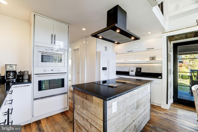 kitchen with dark countertops, white appliances, island exhaust hood, and white cabinetry