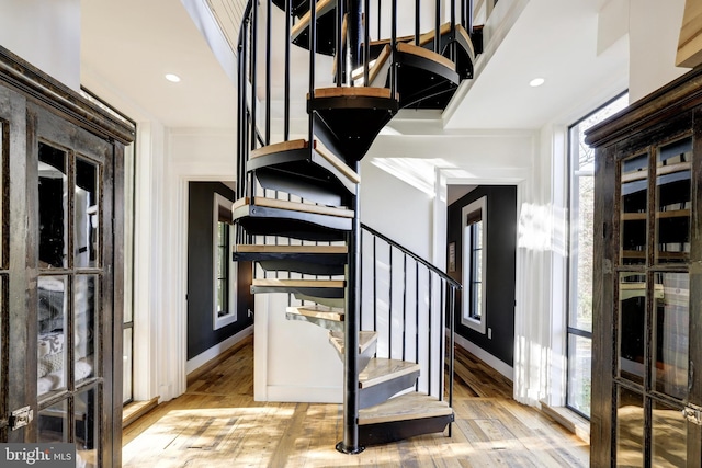 stairs featuring hardwood / wood-style flooring, baseboards, and recessed lighting