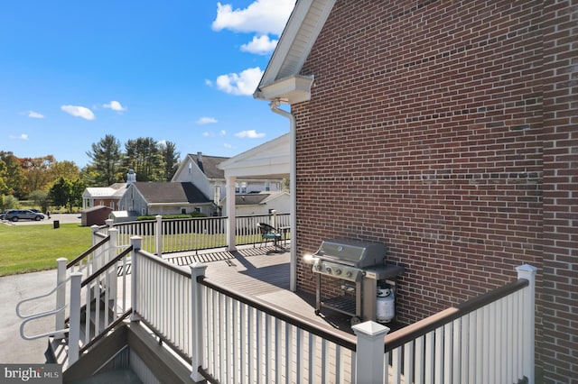 wooden deck featuring grilling area and a yard