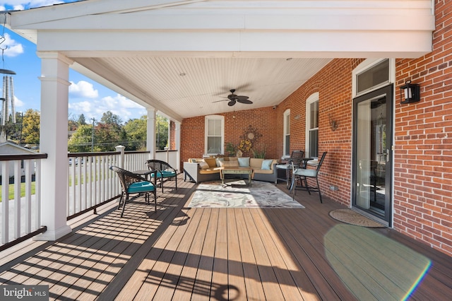 wooden deck featuring outdoor lounge area and ceiling fan