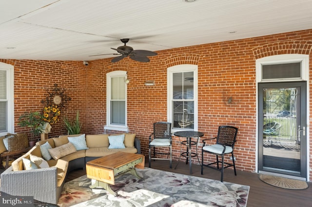 wooden deck with an outdoor living space and ceiling fan