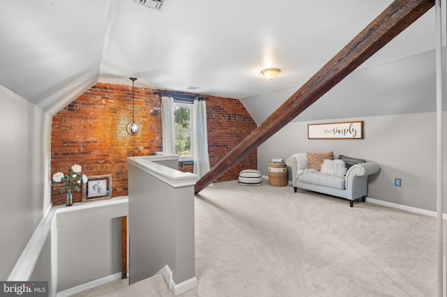 interior space featuring light carpet, brick wall, and vaulted ceiling