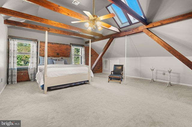 unfurnished bedroom featuring multiple windows, ceiling fan, vaulted ceiling with skylight, and carpet