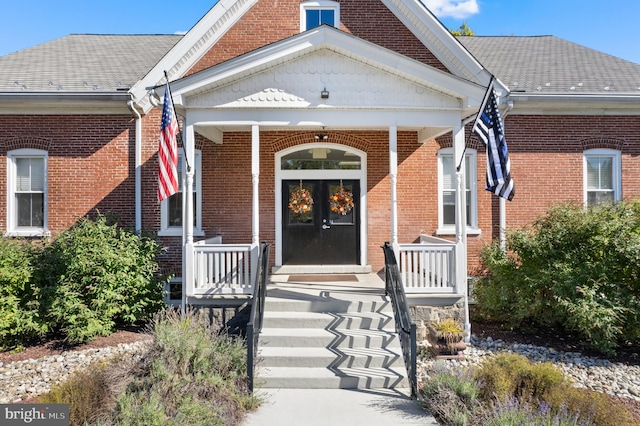 view of exterior entry featuring a porch and french doors