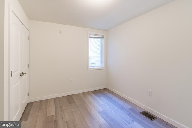 unfurnished bedroom featuring light wood finished floors, baseboards, and visible vents