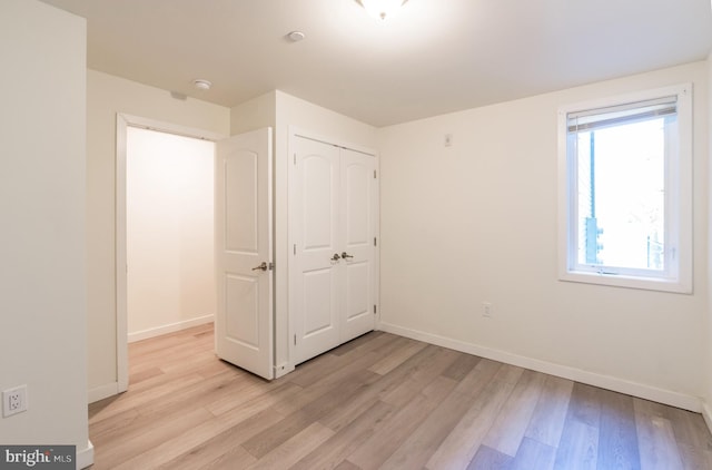 unfurnished bedroom with a closet and light hardwood / wood-style flooring