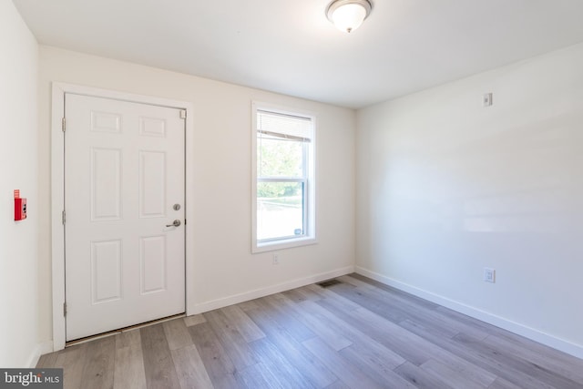 foyer with visible vents, wood finished floors, and baseboards