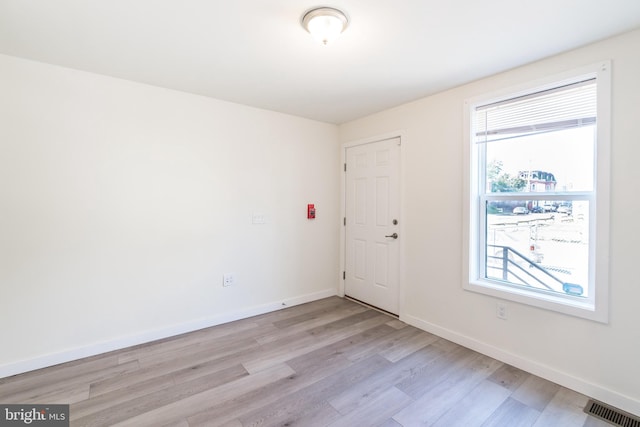 empty room with plenty of natural light and light hardwood / wood-style floors