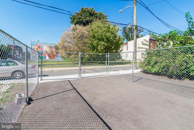 view of basketball court with fence and a gate