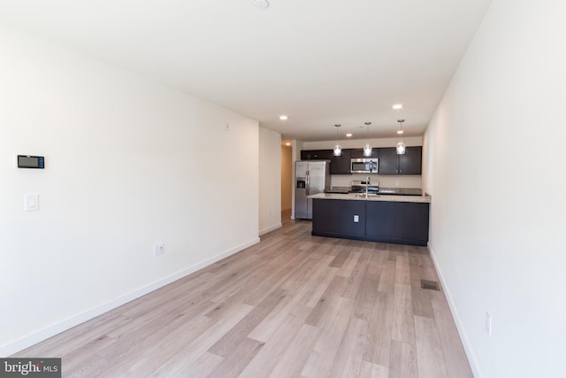 kitchen featuring appliances with stainless steel finishes, visible vents, pendant lighting, light countertops, and light wood-style floors