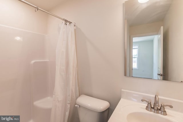 bathroom with vanity, a shower with shower curtain, and toilet