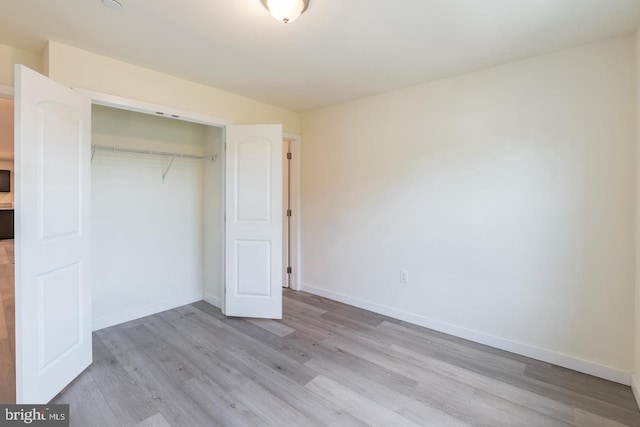 unfurnished bedroom with light hardwood / wood-style flooring and a closet