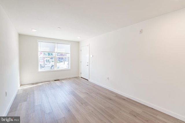 unfurnished room with baseboards, light wood-style flooring, and visible vents