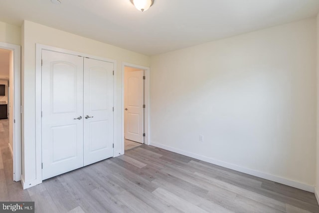 unfurnished bedroom featuring light hardwood / wood-style flooring and a closet