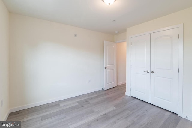 unfurnished bedroom with light hardwood / wood-style floors and a closet