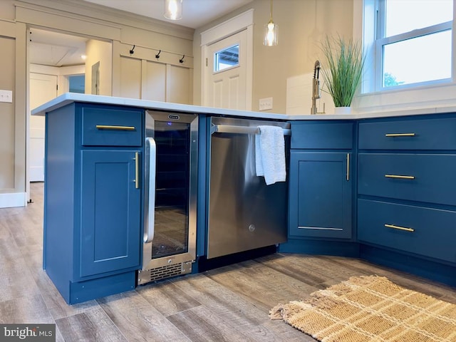 kitchen featuring dishwasher, light hardwood / wood-style flooring, hanging light fixtures, wine cooler, and blue cabinets