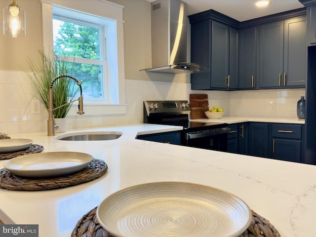 kitchen with electric stove, wall chimney exhaust hood, sink, and blue cabinetry