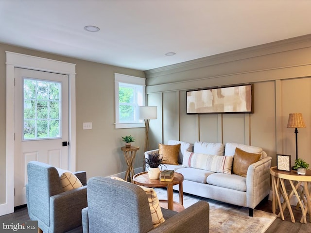 living room featuring dark wood-type flooring and crown molding