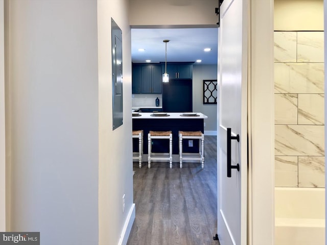 hall with a barn door and dark wood-type flooring