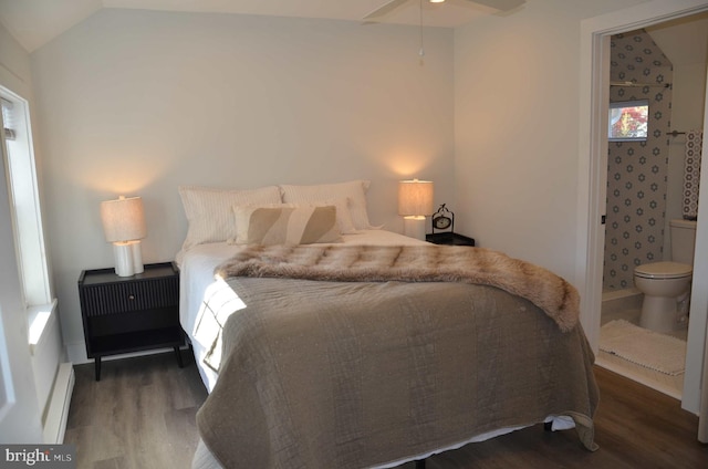 bedroom with ensuite bath, vaulted ceiling, ceiling fan, a baseboard heating unit, and dark wood-type flooring