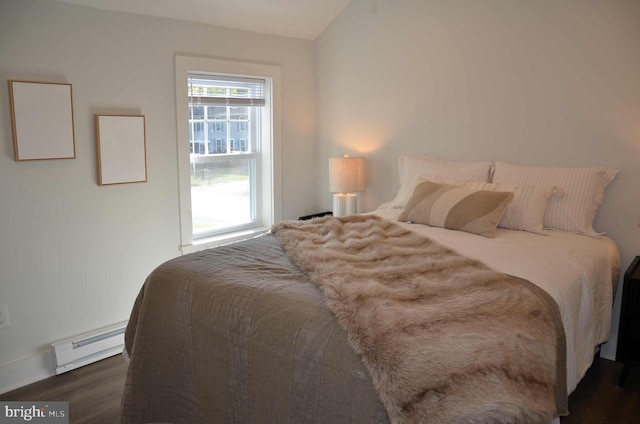 bedroom featuring baseboard heating, dark hardwood / wood-style flooring, and vaulted ceiling