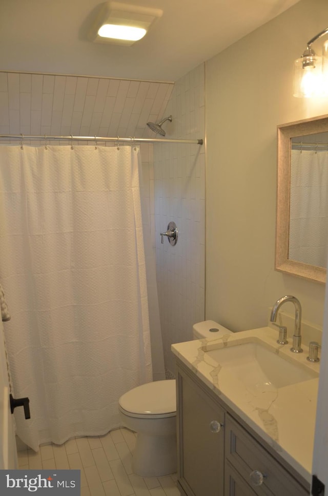 bathroom featuring tile patterned floors, a shower with curtain, vanity, and toilet