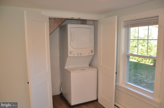 laundry room with stacked washer / dryer and dark wood-type flooring