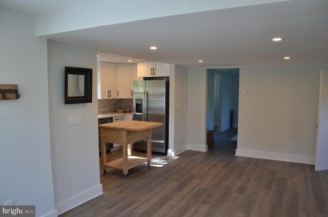 kitchen featuring backsplash, white cabinetry, dark hardwood / wood-style flooring, and stainless steel refrigerator with ice dispenser