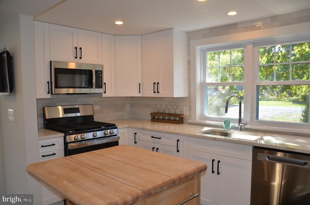 kitchen with stainless steel appliances, white cabinetry, and sink