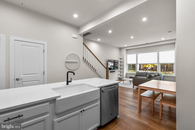 kitchen with light stone countertops, sink, dishwasher, gray cabinets, and dark hardwood / wood-style floors