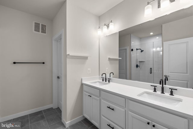 bathroom featuring a shower with door, vanity, and tile patterned floors