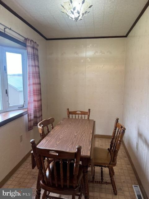 dining area with ornamental molding and a textured ceiling