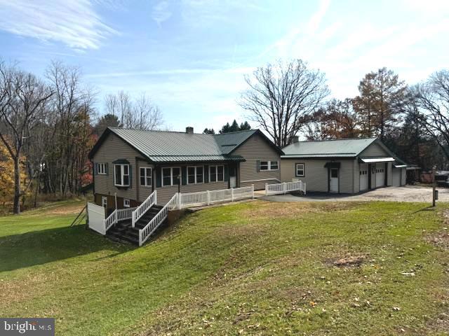 back of property featuring a yard and a garage