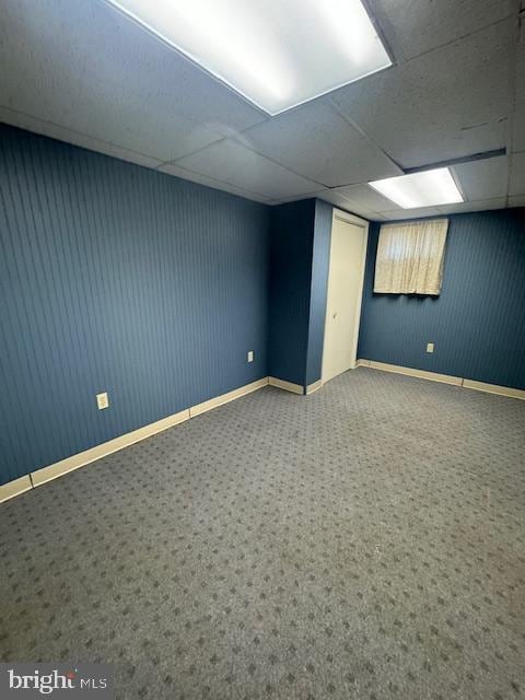 basement featuring carpet flooring and a drop ceiling