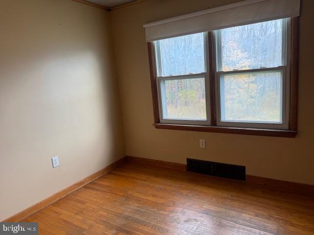 unfurnished room with hardwood / wood-style flooring