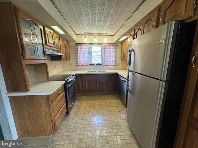 kitchen featuring stainless steel appliances, track lighting, and sink