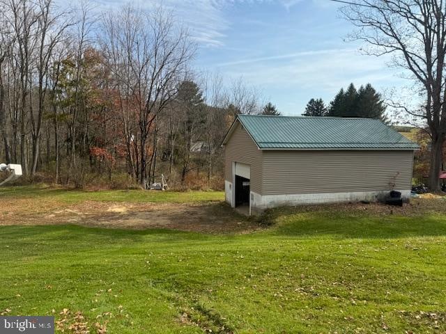 view of side of property with an outdoor structure, a yard, and a garage