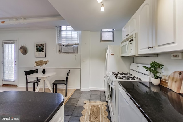 kitchen featuring a healthy amount of sunlight, white cabinetry, white appliances, and dark tile patterned floors