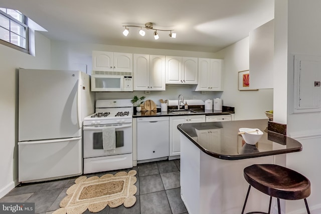 kitchen with white appliances, sink, and white cabinets