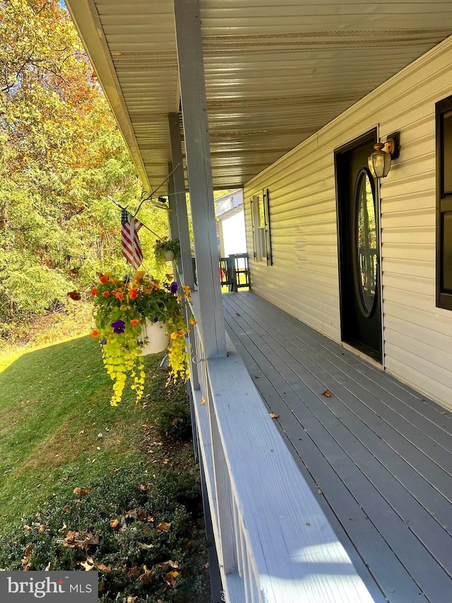 wooden deck featuring a lawn