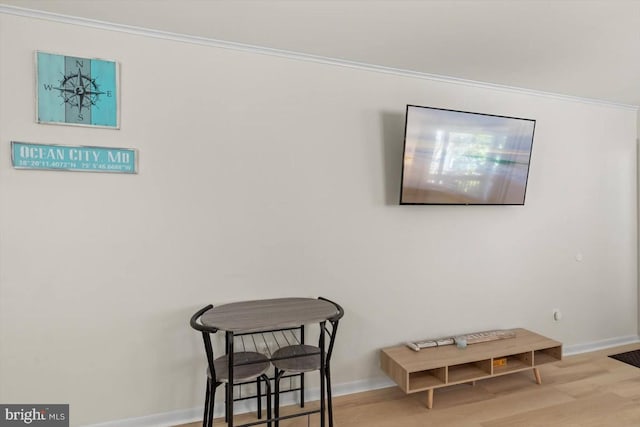 sitting room featuring ornamental molding and light wood-type flooring