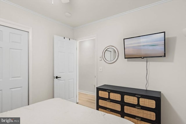 bedroom featuring hardwood / wood-style floors, crown molding, and a closet