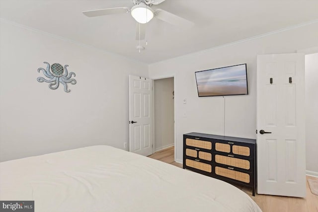 bedroom featuring crown molding, light hardwood / wood-style flooring, and ceiling fan