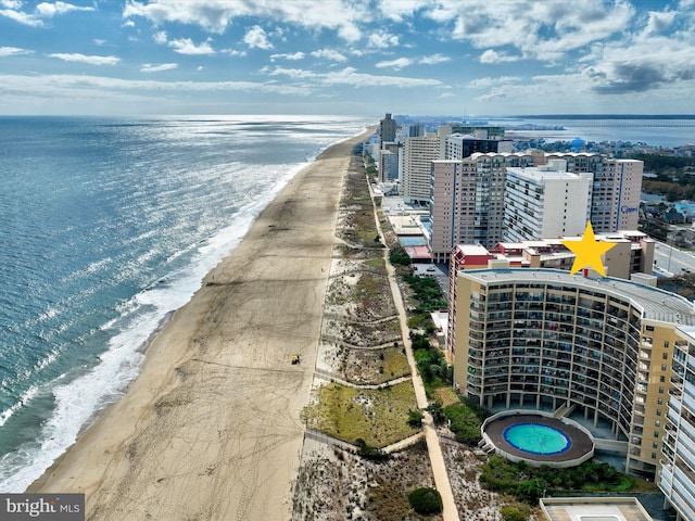 birds eye view of property with a water view and a beach view