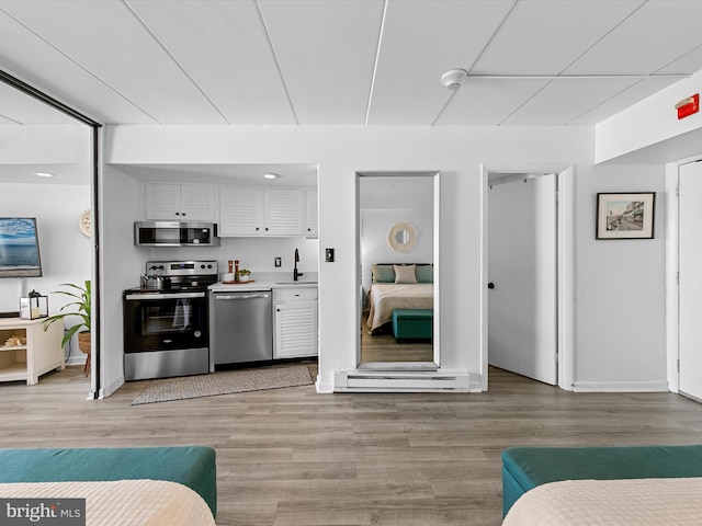 kitchen featuring sink, appliances with stainless steel finishes, light wood-type flooring, and white cabinets